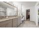 Bright bathroom with double vanity, granite counters, tile floor, and walk-in closet for ample storage at 2198 Broadleaf Loop, Castle Rock, CO 80109