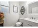 Elegant half-bathroom features a white vanity, patterned mirror, and decorative wall art at 2198 Broadleaf Loop, Castle Rock, CO 80109