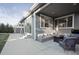 A spacious covered patio with comfortable seating, a fire pit, and sliding glass doors at 2198 Broadleaf Loop, Castle Rock, CO 80109
