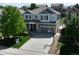 Two-story home with a gray exterior, landscaped yard, and a basketball hoop on the driveway at 2198 Broadleaf Loop, Castle Rock, CO 80109