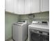A well-equipped laundry room with white cabinets and a modern washer and dryer at 2198 Broadleaf Loop, Castle Rock, CO 80109