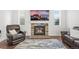 Living room showcasing a stone fireplace with a TV, leather armchair, and patterned rug at 2198 Broadleaf Loop, Castle Rock, CO 80109