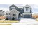 Beautiful two-story home featuring stone accents, gray siding, three-car garage, and well-maintained landscaping at 14247 Beebalm Loop, Parker, CO 80134