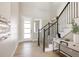 Bright foyer with hardwood floors, black iron stair railing, and a modern front door at 14247 Beebalm Loop, Parker, CO 80134