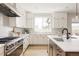 Bright kitchen boasts white cabinets, stainless steel appliances, and light wood floors, perfect for cooking and entertaining at 14247 Beebalm Loop, Parker, CO 80134
