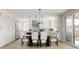 Bright kitchen with island, stainless steel appliances, wood floors, and white cabinets and dining table at 14247 Beebalm Loop, Parker, CO 80134