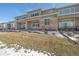 Backyard view of townhomes featuring stone accents and well-kept lawns at 12255 Hazel Spruce Ct, Parker, CO 80134