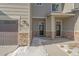 Townhome's front entry with stone accents and covered porch at 12255 Hazel Spruce Ct, Parker, CO 80134