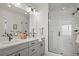 Bathroom features gray cabinets, double sinks, a glass enclosed shower and modern fixtures that exude elegance and functionality at 16637 Shoshone St, Broomfield, CO 80023
