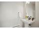 An elegant bathroom features a pedestal sink, white walls, and a towel rack, creating a serene and modern space at 16637 Shoshone St, Broomfield, CO 80023
