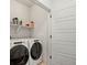 Laundry room with a white washer and dryer set, storage shelf, and clean finishes at 16637 Shoshone St, Broomfield, CO 80023