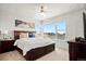 Spacious main bedroom features a large bed, modern ceiling fan, and neighborhood views from a wide, sunlit window at 16637 Shoshone St, Broomfield, CO 80023