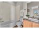 Bathroom with a shower and tub combo, wood vanity, and a neutral-colored vanity top at 3372 Central Park Blvd, Denver, CO 80238