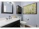 Powder bathroom featuring a black framed mirror, white vanity, and blue walls at 2370 W 152Nd Ave, Broomfield, CO 80023