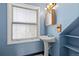 Bright bathroom with white pedestal sink, window with blinds and a unique blue paint at 2370 W 152Nd Ave, Broomfield, CO 80023