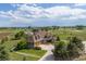 Stunning home exterior with lush green landscape, circular driveway, and sprawling acreage at 2370 W 152Nd Ave, Broomfield, CO 80023