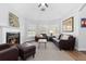 Bright living room with fireplace, leather sofas, and ample natural light from multiple windows at 2370 W 152Nd Ave, Broomfield, CO 80023