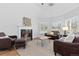 Bright living room with fireplace, leather sofas, and ample natural light from multiple windows at 2370 W 152Nd Ave, Broomfield, CO 80023