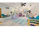 Bright rec room with mirrored wall, neutral carpet, ceiling fan, windows, sofa, loveseat, area rug, and exercise equipment at 2370 W 152Nd Ave, Broomfield, CO 80023