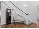 Bright foyer featuring hardwood floors, staircase with gray carpet and white railing, bench, and grandfather clock at 2370 W 152Nd Ave, Broomfield, CO 80023