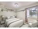 Comfortable bedroom with light walls, window view, shelves and soft, modern furnishings at 3124 S Wheeling Way # 102, Aurora, CO 80014