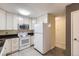 Well-lit kitchen featuring white cabinets, black countertops, and modern appliances at 3124 S Wheeling Way # 102, Aurora, CO 80014