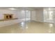 Open basement floor plan featuring tiled and carpeted flooring near a brick fireplace at 6288 S Harlan Way, Littleton, CO 80123
