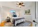 Bedroom with ceiling fan, neutral walls, hardwood floors, two windows, and white trim at 6288 S Harlan Way, Littleton, CO 80123