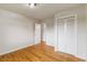 Bright bedroom features hardwood floors, closet with bifold doors, and white doors at 6288 S Harlan Way, Littleton, CO 80123