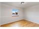 Bright bedroom featuring hardwood floors, fresh paint, and a window with neighborhood views at 6288 S Harlan Way, Littleton, CO 80123