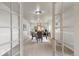 Inviting dining room featuring neutral walls, carpet and a table setting, viewed through glass French doors at 6288 S Harlan Way, Littleton, CO 80123