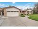 Spacious driveway leads to a brick home with an attached garage and a well-maintained lawn at 6288 S Harlan Way, Littleton, CO 80123
