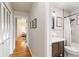 Hallway leading to bath with upgraded vanity, paint, shower, and fixtures at 6288 S Harlan Way, Littleton, CO 80123