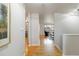 Hallway featuring hardwood floors, white walls, and a view into the living room and dining area at 6288 S Harlan Way, Littleton, CO 80123