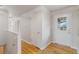 Bright hallway with hardwood floors, white walls, and doors leading to other rooms at 6288 S Harlan Way, Littleton, CO 80123