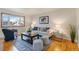 Cozy living room with hardwood floors, stylish decor, and natural light from a large window at 6288 S Harlan Way, Littleton, CO 80123