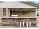 The covered outdoor kitchen and bar area feature a stone facade at 6288 S Harlan Way, Littleton, CO 80123