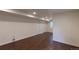 Finished basement with neutral walls, wood-look flooring, bright recessed lighting, and convenient closet at 10581 Pearlwood Cir, Highlands Ranch, CO 80126