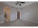 Carpeted primary bedroom features a ceiling fan and multiple entry doors at 10581 Pearlwood Cir, Highlands Ranch, CO 80126