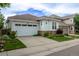 Charming home with an attached garage, stone accents, a well-manicured lawn, and beautiful landscaping at 10581 Pearlwood Cir, Highlands Ranch, CO 80126