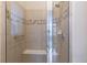 Modern shower with a glass door, built-in bench, tiled walls and neutral tones offers a spa-like experience at 10581 Pearlwood Cir, Highlands Ranch, CO 80126