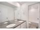 Bathroom featuring dual sinks, a large mirror, and a separate room with a toilet and bathtub/shower combination at 5601 Inland Ave, Firestone, CO 80504