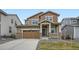 Inviting two-story home with a charming front porch, a well-manicured lawn, and an attached two-car garage at 5601 Inland Ave, Firestone, CO 80504