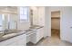 Modern main bathroom featuring dual sinks, a walk-in shower with glass door, and a large mirror at 5601 Inland Ave, Firestone, CO 80504