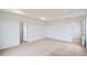 Bright main bedroom with a tray ceiling, neutral carpet, and access to the en-suite bathroom and walk-in closet at 5601 Inland Ave, Firestone, CO 80504