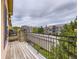 Relaxing balcony featuring wood flooring, iron railing, and views of nearby townhomes and landscaping at 3155 E 104Th Ave # 4E, Thornton, CO 80233