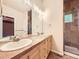 Well-lit bathroom with double sinks, granite countertops, and a glass-enclosed shower at 3155 E 104Th Ave # 4E, Thornton, CO 80233