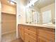 Bathroom featuring a double sink vanity with wood cabinets and a large mirror, with a walk-in closet at 3155 E 104Th Ave # 4E, Thornton, CO 80233