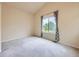 Bright bedroom featuring a large window with stylish curtains, neutral colors, and plush carpeting at 3155 E 104Th Ave # 4E, Thornton, CO 80233