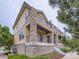 Multi-level home featuring stone-clad pillars, upper and lower balconies, and a landscaped exterior at 3155 E 104Th Ave # 4E, Thornton, CO 80233